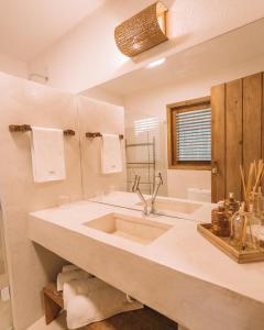 a bathroom with a large sink and a mirror at Pousada Awêry Caraíva in Caraíva