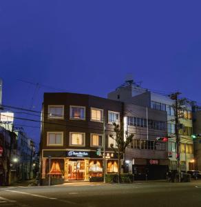 a building on the corner of a street at night at 大同 Garden Hotel in Osaka