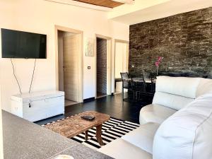 ein Wohnzimmer mit einem weißen Sofa und einem Tisch in der Unterkunft Panoramic Taormina Bay View in Taormina