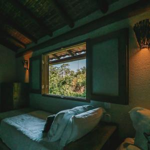 a bedroom with a window and a bed in a room at Pousada Awêry Caraíva in Caraíva