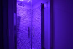 W łazience znajduje się przeszklony prysznic z fioletowym oświetleniem. w obiekcie Barlaman Luxury Rooms w mieście Palermo