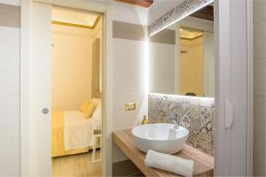 a bathroom with a sink and a bed in a room at Barlaman Luxury Rooms in Palermo
