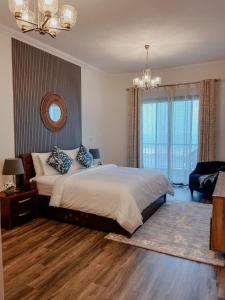 a bedroom with a large bed and a chandelier at Mina AlFajer Apartments in Dibba