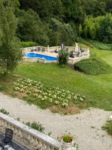 uma piscina num quintal com flores brancas em Chateau de Clinzeau em Saint-Léger-de-Fougeret