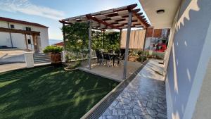 a patio with a table and chairs under a pergola at Bilić S in Dugi Rat