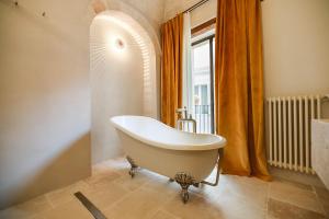 a white bath tub in a bathroom with a window at BAYIT Charming Place in Polignano a Mare