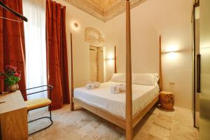 a bedroom with a four poster bed in a room at BAYIT Charming Place in Polignano a Mare
