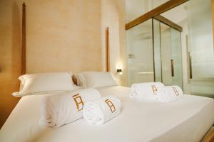 two beds with white pillows and a mirror at BAYIT Charming Place in Polignano a Mare