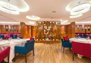 a dining room with tables and chairs and chandeliers at Ferdi Lilly in Ben ʼAknoûn