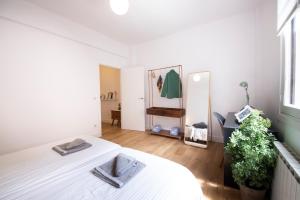 a white bedroom with a bed and a mirror at Playa Zurriola in San Sebastián