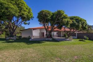 a house with trees in front of a yard at Pouso da Soraya in Rio de Contas
