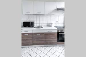 a white kitchen with wooden cabinets and a sink at Zentral, ruhig, 4Personen, Balkon, Waschmaschine in Chemnitz