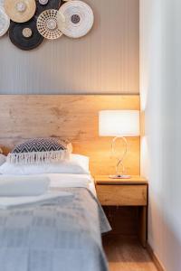 a bedroom with a bed and a table with a lamp at Apartamenty Kozubnik - Apartament 16 z dużym tarasem in Porąbka