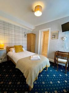 a bedroom with a bed and a table and a chair at Bryn Noddfa in Morfa Nefyn