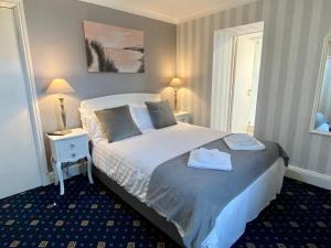 a bedroom with a bed and two tables and two lamps at Bryn Noddfa in Morfa Nefyn