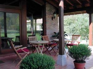a patio with tables and chairs on a porch at La Ablaneda in Soto de Cangas