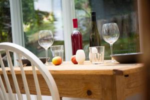 HegymagasにあるVinonima Vendégházの木製テーブル(ワイングラス付)とワイン1本