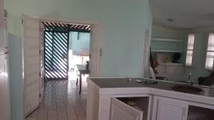 een keuken met een wastafel en een deur naar een kamer bij Casa aBeira Mar 200 metros da praia Peruíbe in Peruíbe