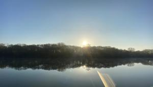 a view of the sun rising over a lake at Paris Camping Ile du Roi in Triel-sur-Seine