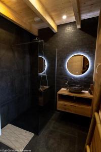 a bathroom with a shower and a sink and a mirror at Les Jardins du Hérisson Chalet 2 in Bonlieu