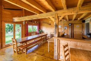 a dining room with a long wooden table and chairs at Refuge Sous La Joux in Les Moussières