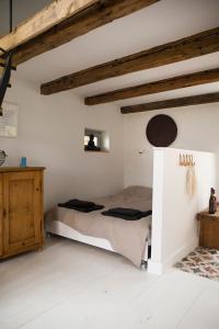 a bedroom with a bed in a room with wooden ceilings at Vinonima Vendégház in Hegymagas