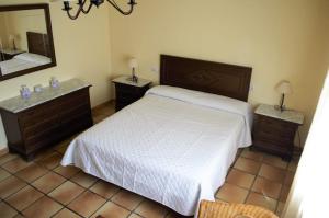 um quarto com uma cama, 2 mesas de cabeceira e um espelho em Casa Rural El Huerto del Trucho em Oliete