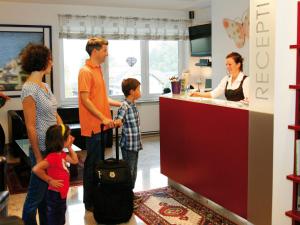 a group of people standing in a kitchen at Hotel Ferienwohnungen Gabriel in Keutschach am See