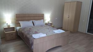 a bedroom with a large bed with two towels on it at Elegant Hotel in Kutaisi