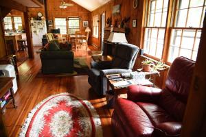 een woonkamer met een bank, stoelen en een tafel bij Fox Trot Cabin in Meadows of Dan