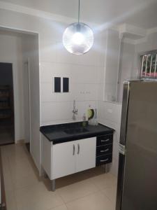a kitchen with a sink and a refrigerator at Apartamento Boqueirao in Praia Grande