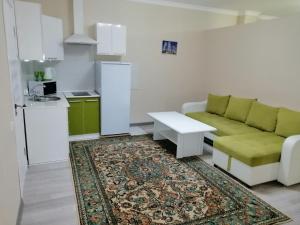 a living room with a couch and a table at Apart Hotel 36 этаж in Astana