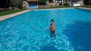 un hombre está parado en una piscina en APT. CON VISTAS ISLAS MEDAS, en Girona