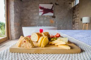 um prato de queijo e pão sobre uma mesa em Hotel de Tierra Viñedo y Spa - Aeropuerto Querétaro em San Vicente