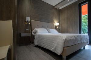 - une chambre avec un grand lit et une grande fenêtre dans l'établissement Hotel Tre Ville, à Parme