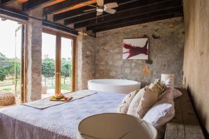 a bedroom with a bed and a bath tub at Hotel de Tierra Viñedo y Spa - Aeropuerto Querétaro in San Vicente