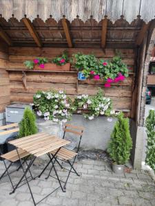 eine Holzwand mit einem Tisch, Stühlen und Blumen in der Unterkunft Studio FranGiò in Interlaken