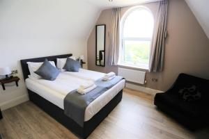 um quarto com uma cama grande e uma janela em Hotel Tia em Liverpool