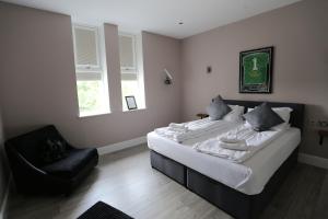 1 dormitorio con 2 camas y 1 silla en Hotel Tia en Liverpool
