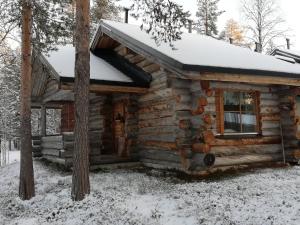 eine Blockhütte mit Schnee auf dem Dach in der Unterkunft Korpikelo in Ylläsjärvi