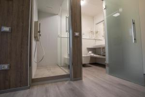 a bathroom with a walk in shower next to a walk in closet at Hotel Tre Ville in Parma