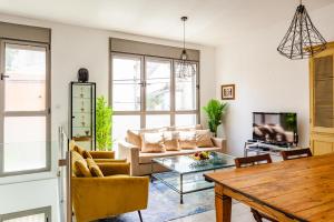 uma sala de estar com um sofá e uma mesa em Superior and Spacious Duplex in the Kerem em Tel Aviv