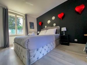 1 dormitorio con 1 cama grande con corazones en la pared en Joli studio avec jardin - Gare RER C -proche PARIS en Brétigny-sur-Orge