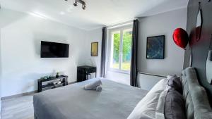 a bedroom with a bed and a couch and a window at Joli studio avec jardin - Gare RER C -proche PARIS in Brétigny-sur-Orge