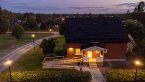 una pequeña casa de ladrillo con techo negro por la noche en Thunor B&B en Skellefteå