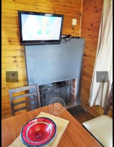 a living room with a fireplace and a television at Fama in Punta Del Diablo