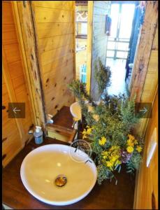 un baño con lavabo y un ramo de flores en Fama en Punta del Diablo