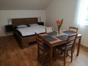 1 dormitorio con mesa de comedor y 1 cama en Apartmány HABR, en Nové Město pod Smrkem