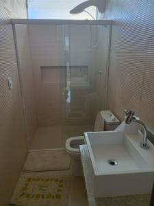 y baño con ducha, lavabo y aseo. en Casa alto padrão com piscina em Condomínio Fechado, en Barra de São Miguel