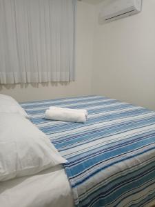 una cama con una toalla enrollada encima en Casa alto padrão com piscina em Condomínio Fechado, en Barra de São Miguel